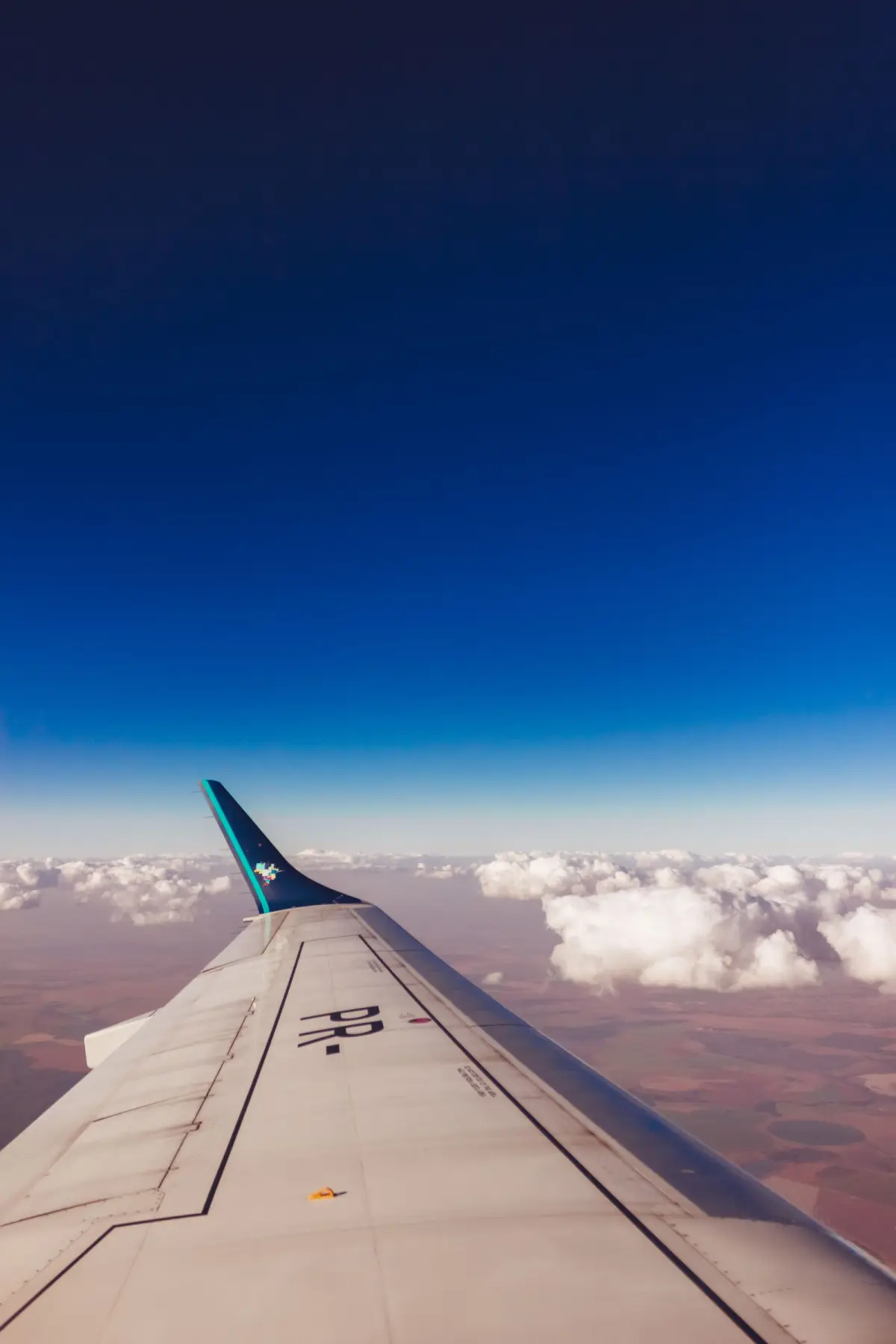 Aircraft wing above the clouds representing aerospace and space composite applications