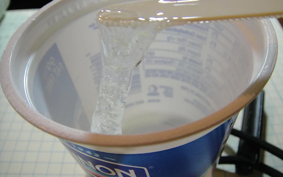 Clear epoxy resin and hardener being mixed for composite production